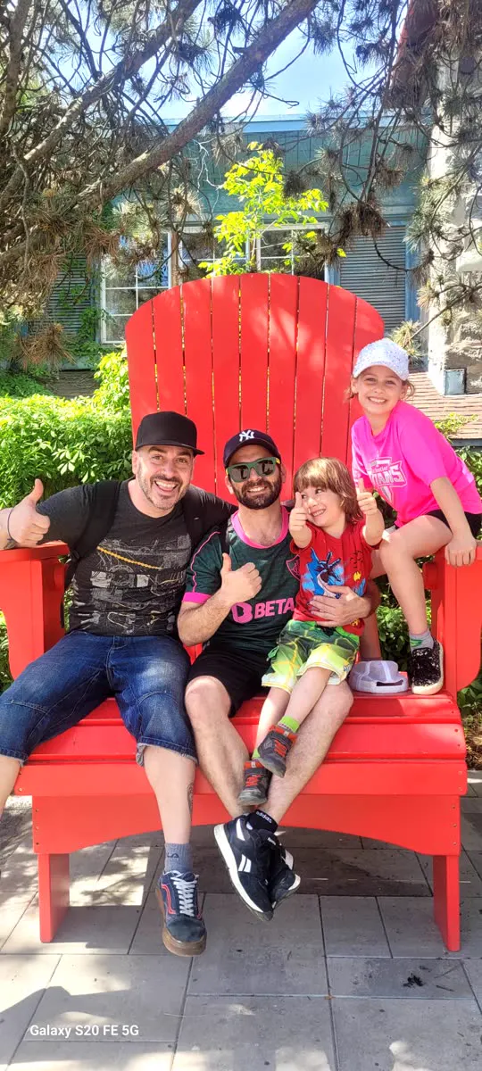 Two adults and two children sitting in a large red chair