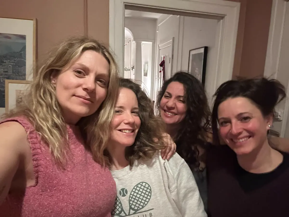 Four women take a selfie together at home