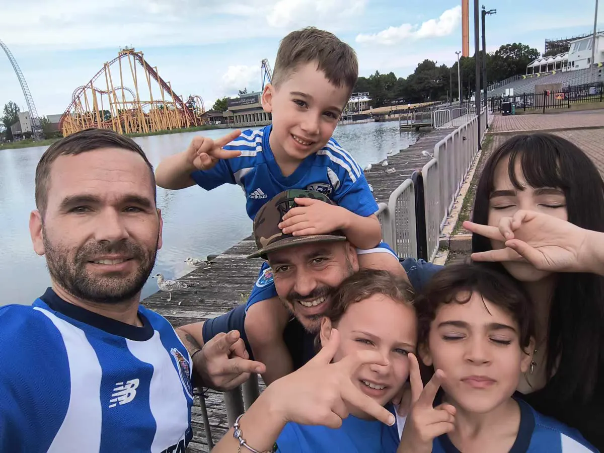 Family selfie in football jerseys by the water